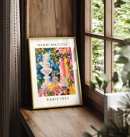 Framed artwork of a Greek mythology bust with citrus fruits and vivid patterns.